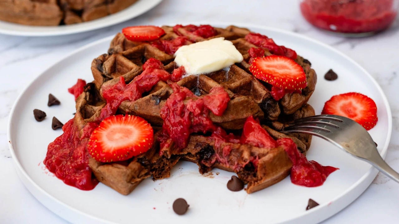 plate of gluten free chocolate waffles with strawberry reduction