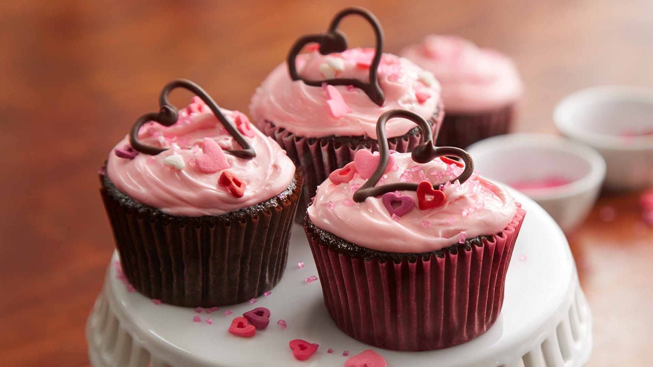 chocolate cupcakes with pink icing and topped with chocolate hearts