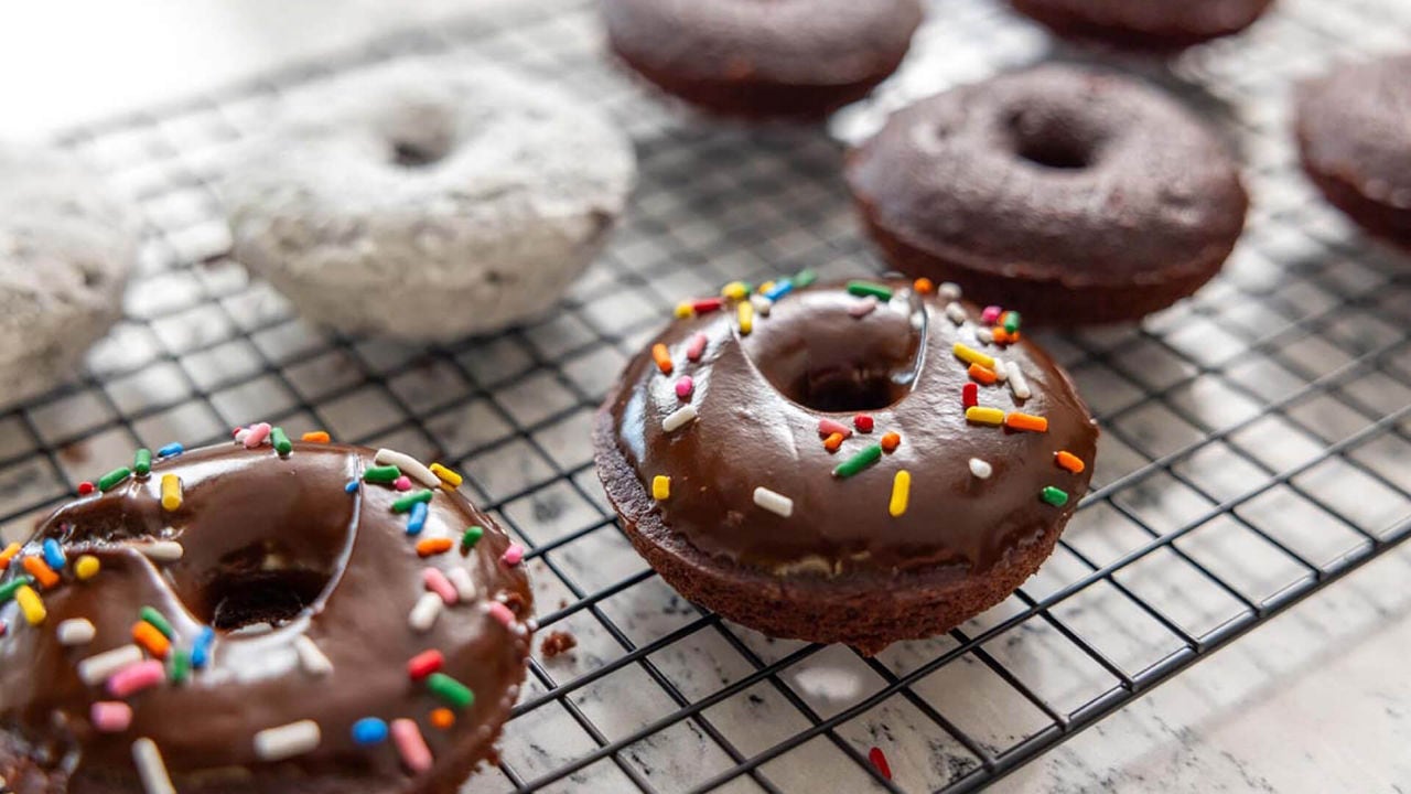 batch of chocolate cake donuts cooling on wire rack