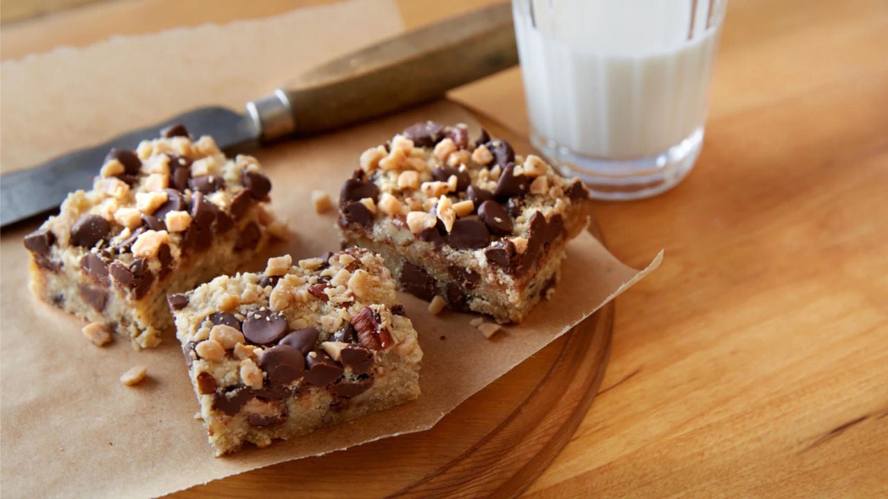 batch of chocolate chip toffee bars next to glass of milk