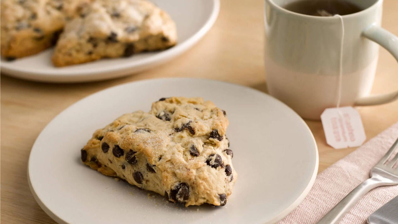 special dark chocolate chip scone beside mug of tea