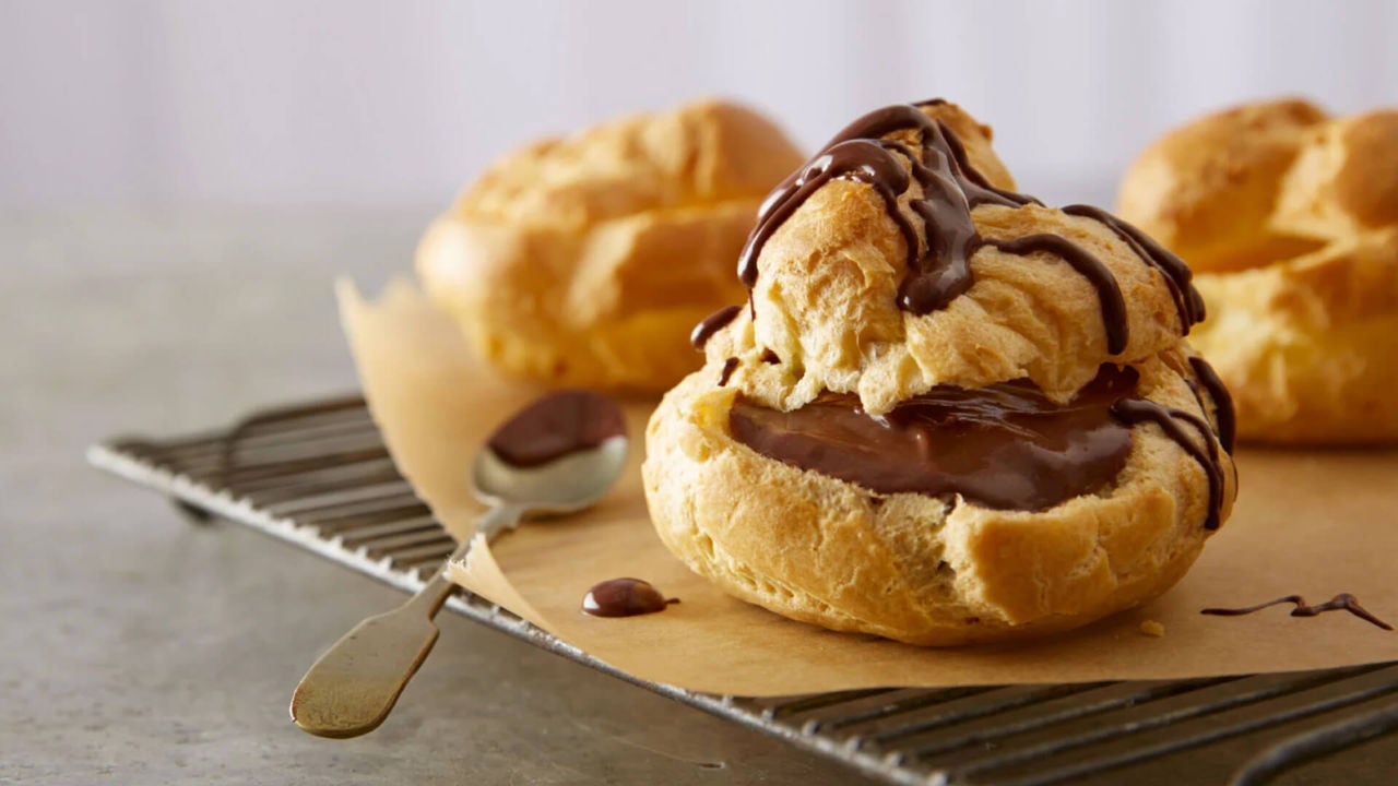 batch of rich chocolate glazed cream puffs