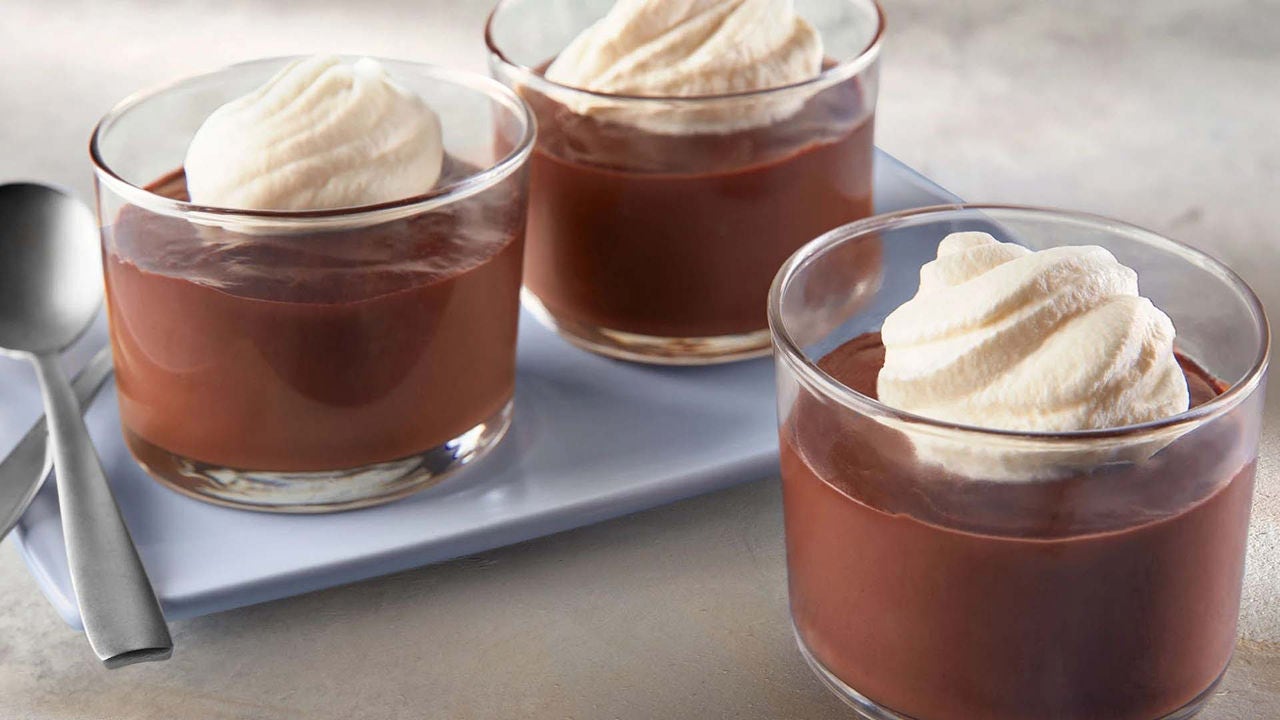 glasses filled with creamy chocolate pudding topped with whipped cream