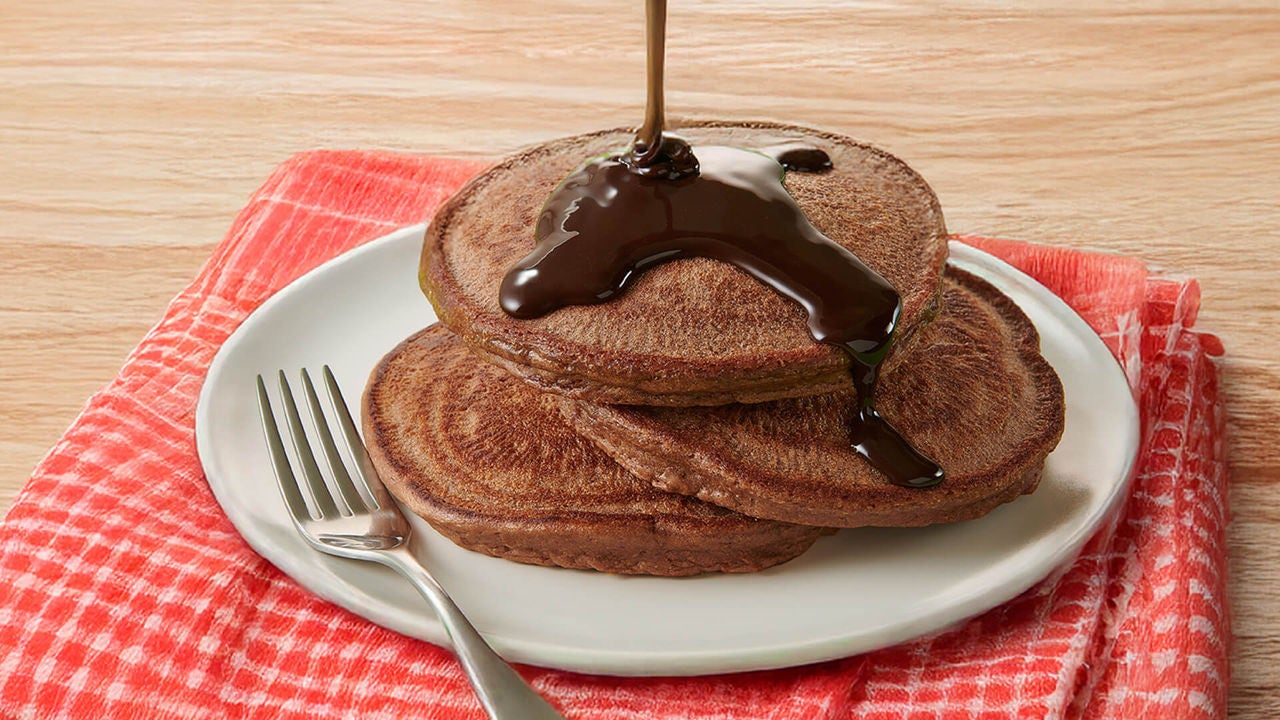 stack of chocolate pancakes topped with hersheys chocolate syrup