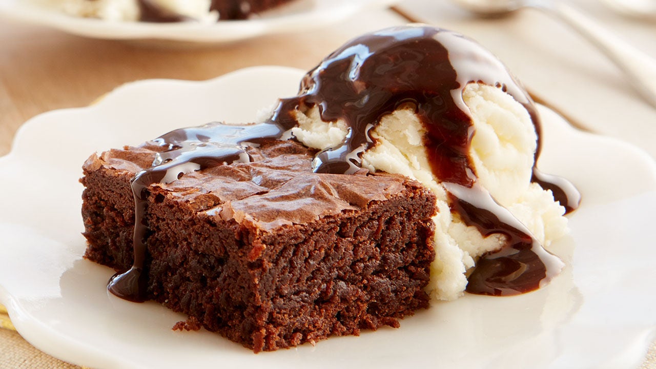 plated brownie with vanilla ice cream both drizzled with hersheys chocolate syrup