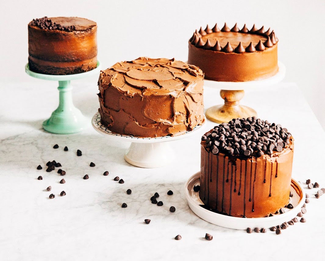 multiple decorated cakes on pedestals