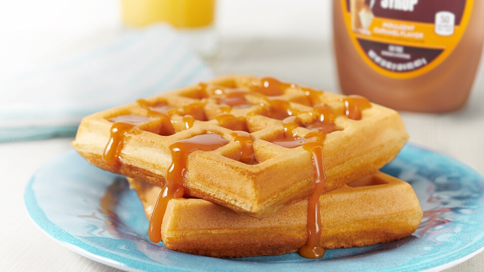 stacked waffles drizzled with with hersheys caramel syrup