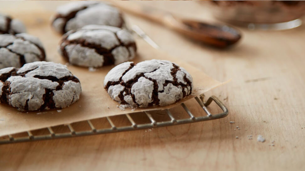 batch of cocoa crinkle cookies cooling on wire rack