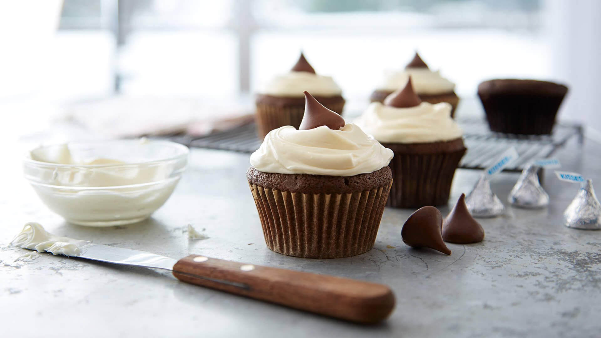 topping chocolate cupcakes with vanilla frosting and hersheys kisses milk chocolates