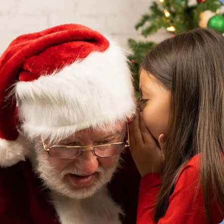 little girl whispering in santa's ear