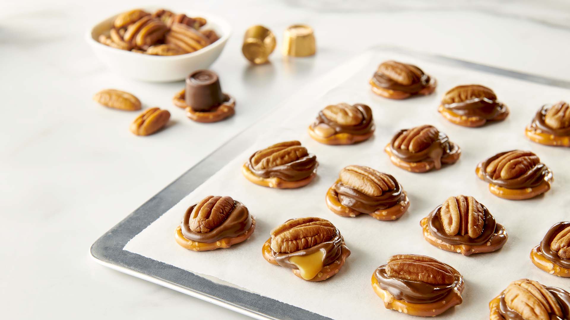 pressing one pecan on top of the fully melted rolo creamy caramels