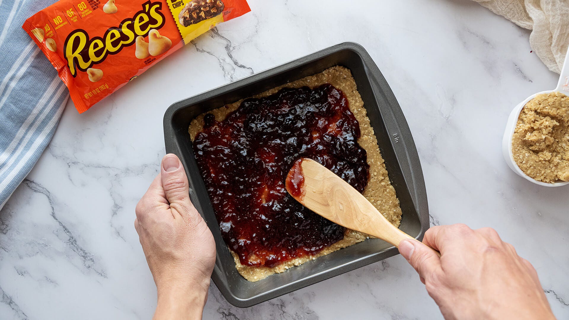 spreading jelly over mixture in the pan 