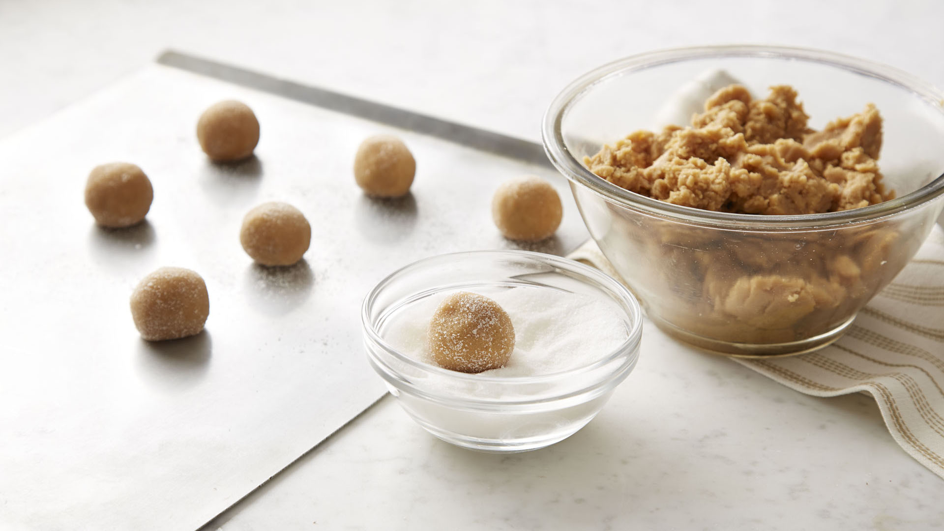 shaping dough into balls and placing on an ungreased cookie sheet