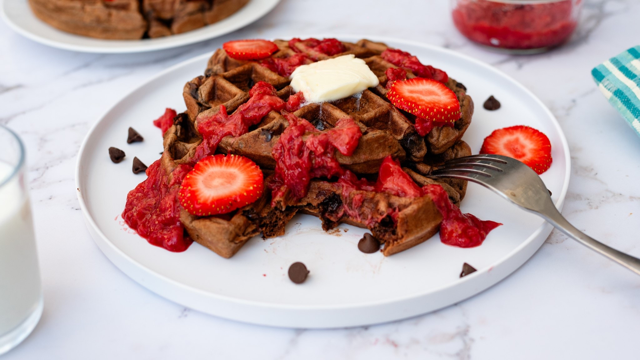 stack of chocolate chip waffles with strawberry reduction