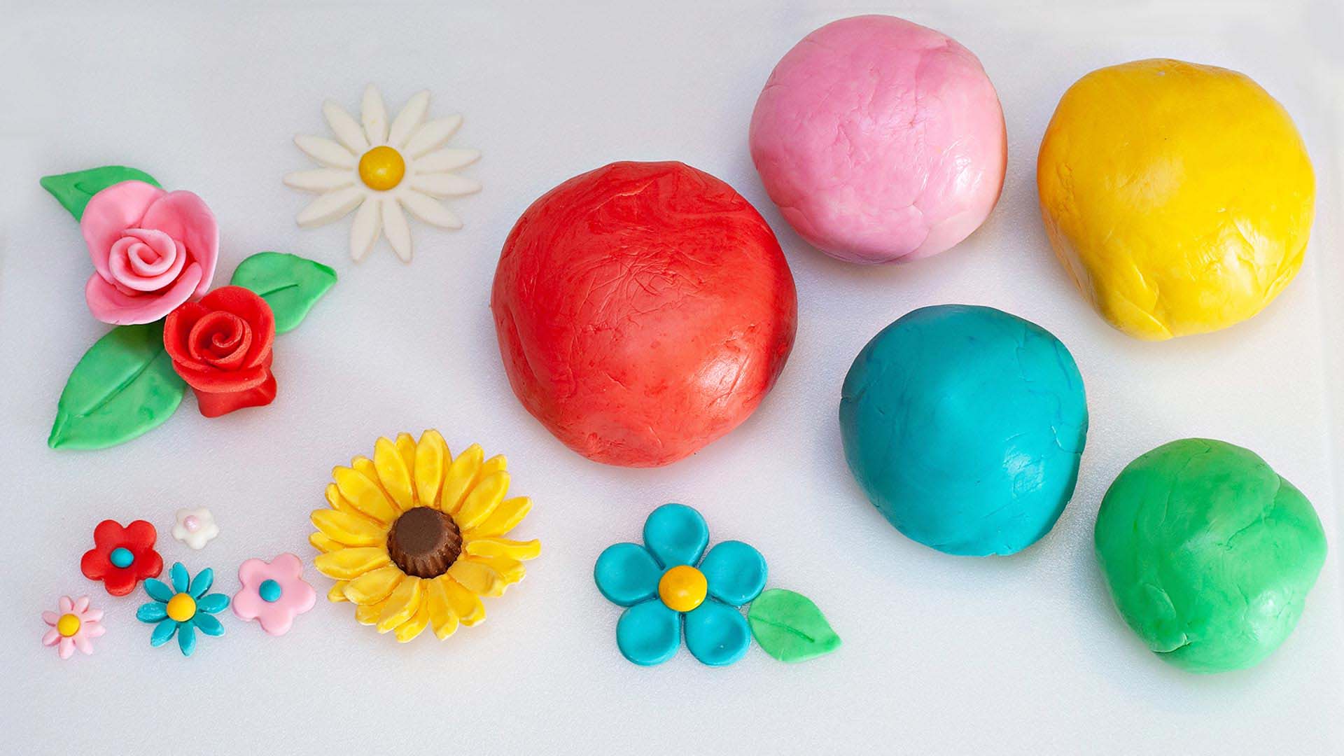 multiple colors of fondant molded into edible spring flowers