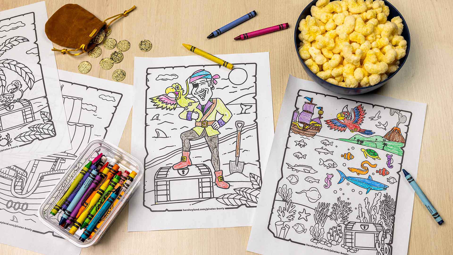 pirates booty mascots and landscapes coloring pages with crayons scattered across tabletop