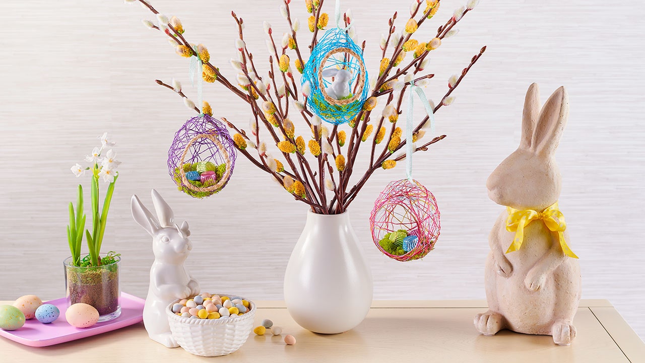 spring floral in white vase next to bunny statues