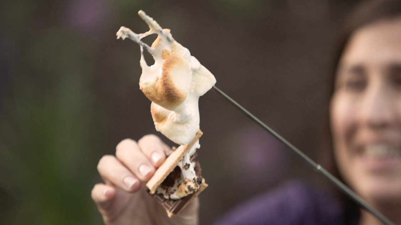 adding campfire roasted marshmallow to a smore