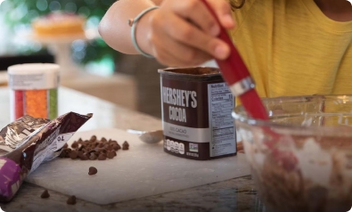 person stirring baking ingredients in mixing bowl