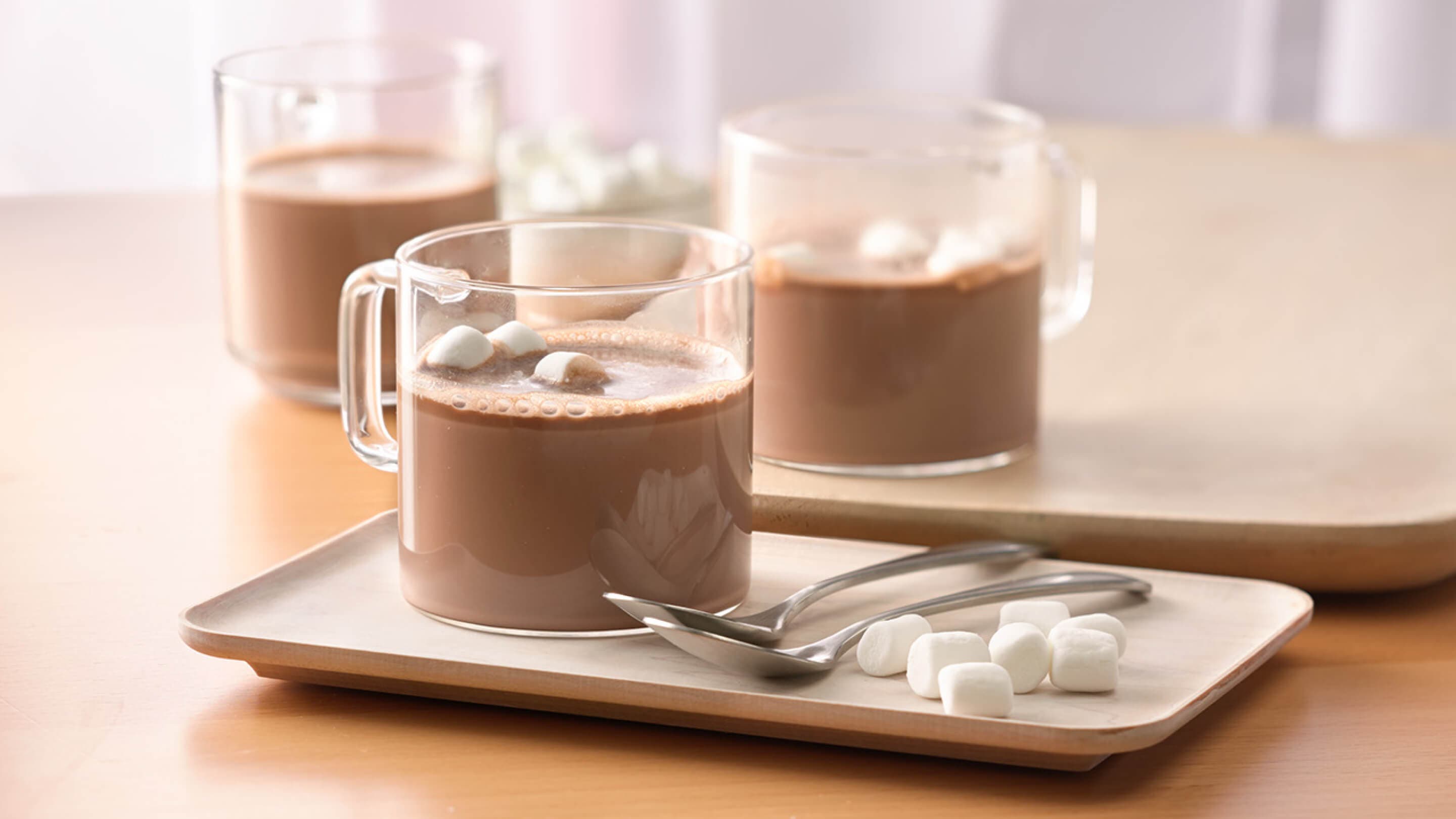 three glass mugs full of hot cocoa