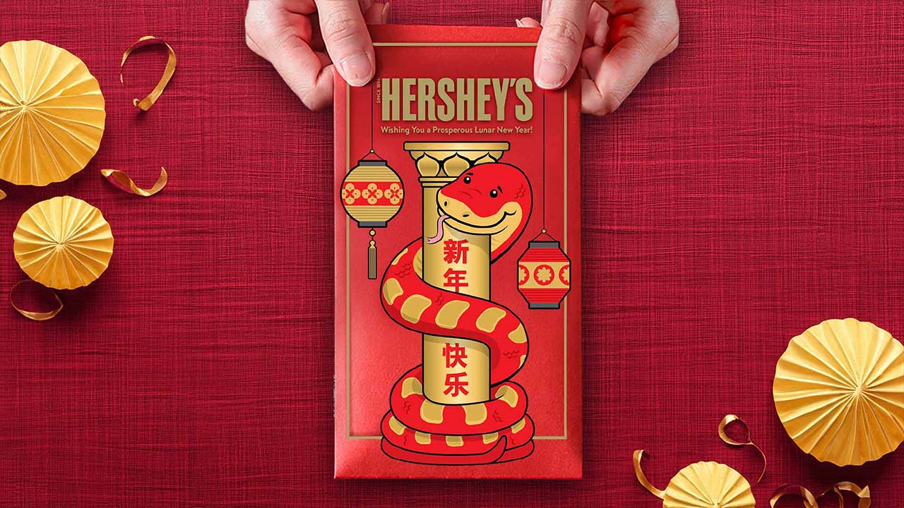 person holding a candy bar wrapped in a lunar new year candy bar wrapper