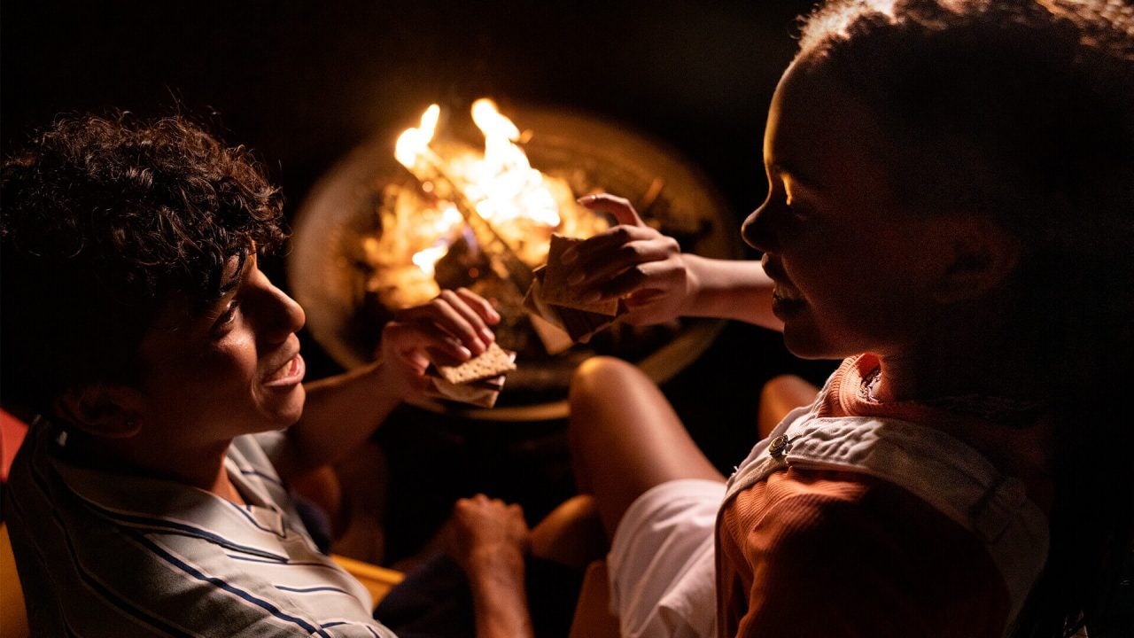 two friends enjoying hersheys smores by the campfire